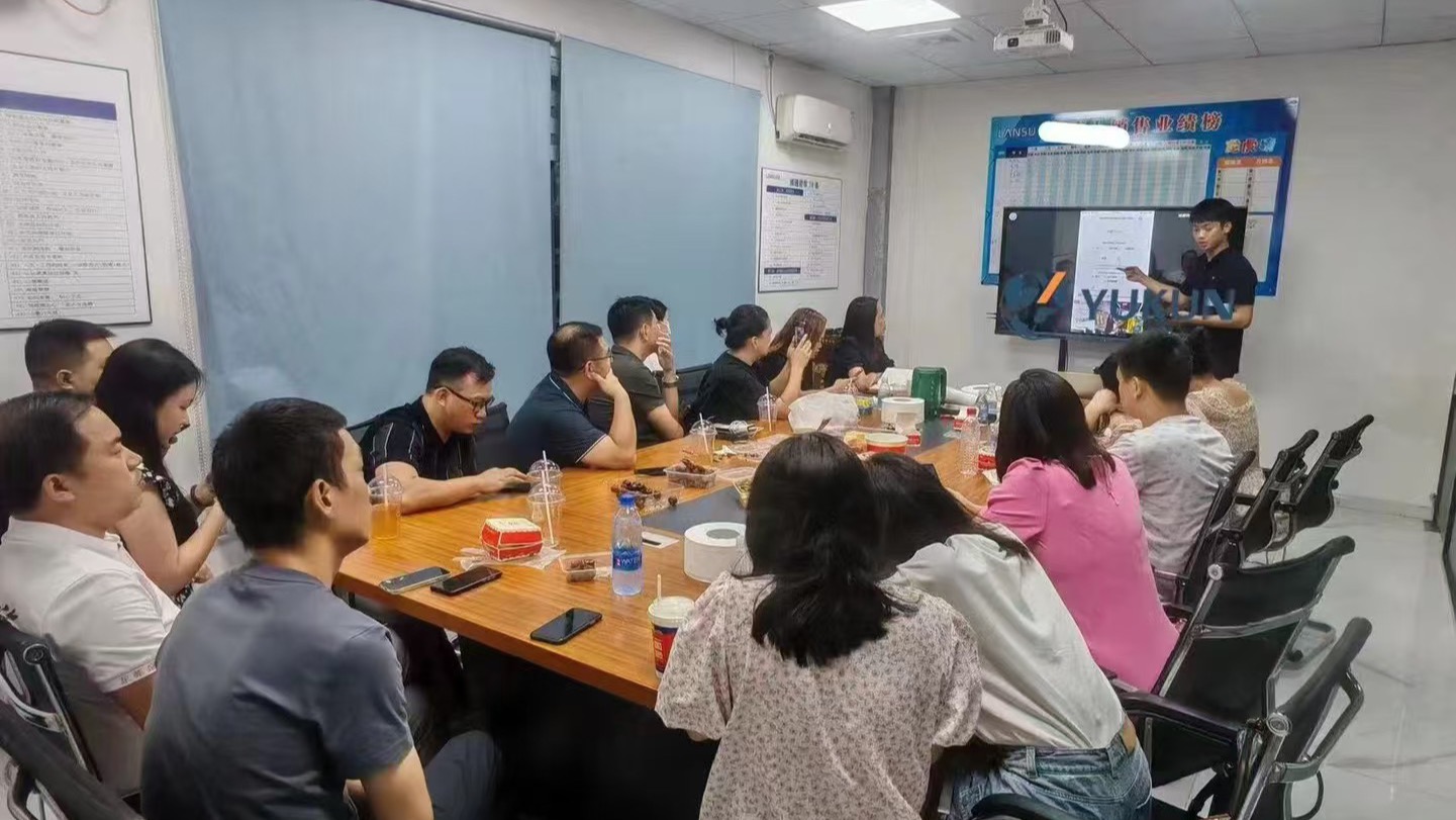 玉昆科技团队在客户办公室做上门培训，会议室屏幕显示玉昆官网
